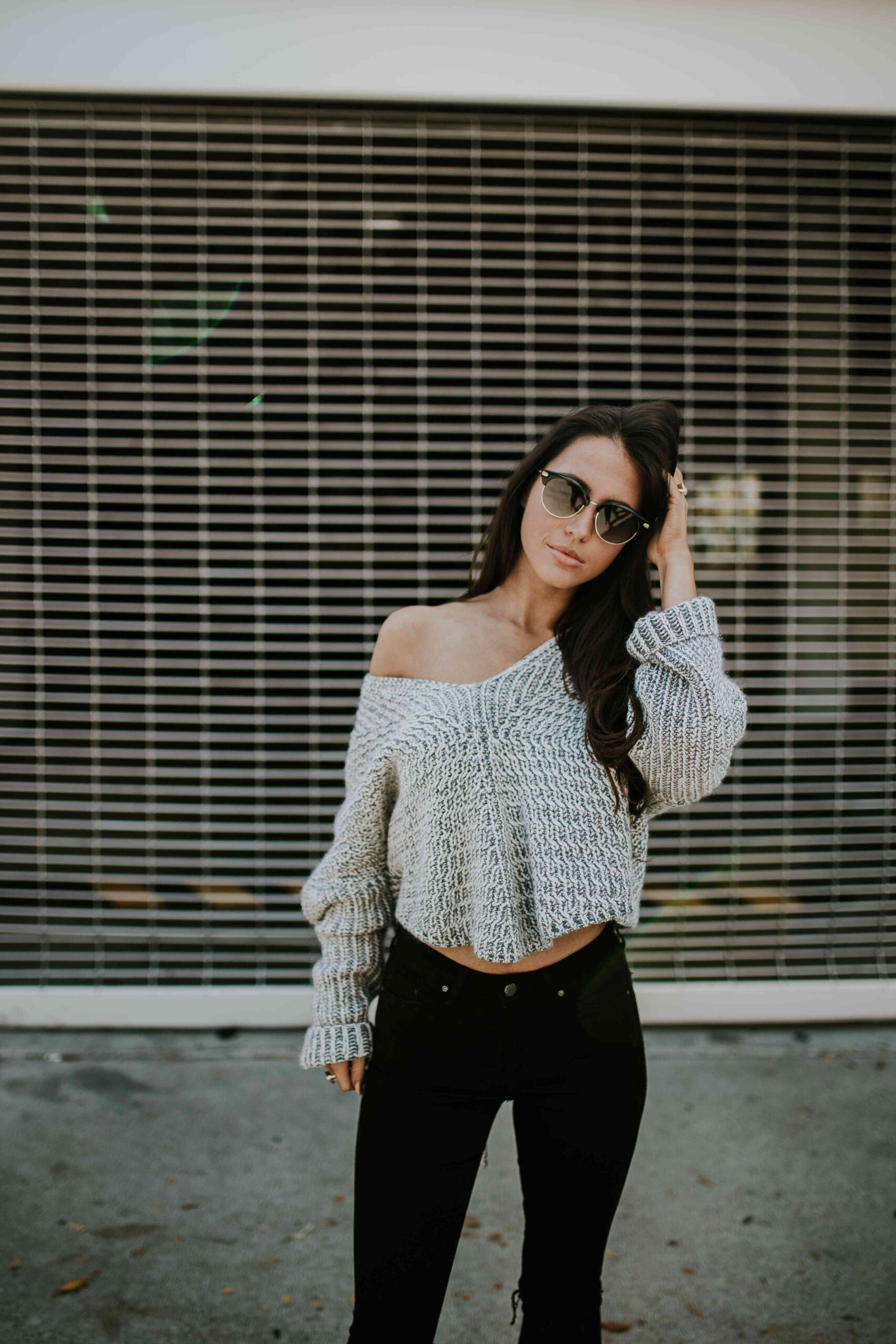 woman wearing tight knitted jumper with sunglasses and heans